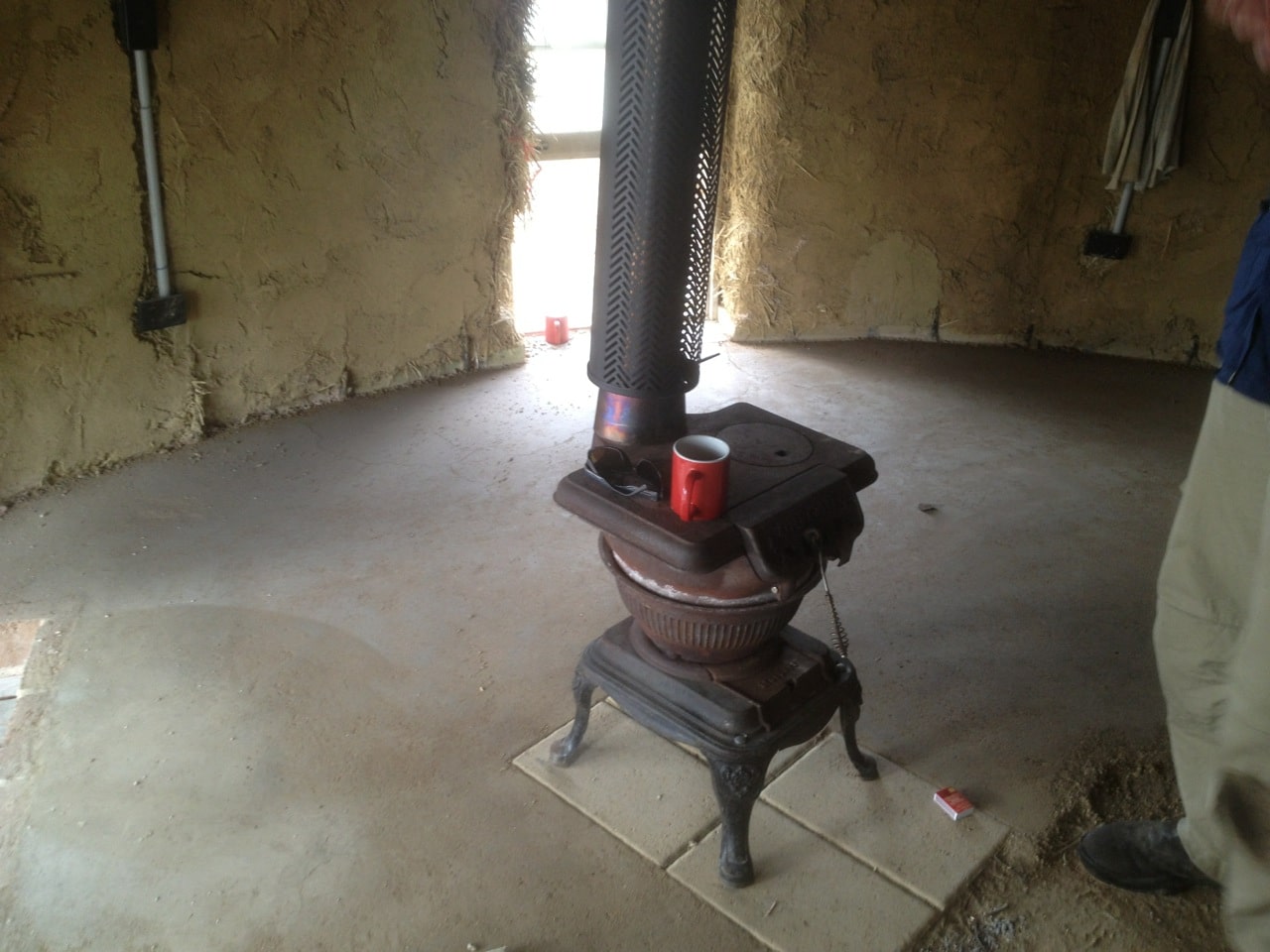 Roundhouse build: the stove is in! And check out that earth floor - it's nearly done too...