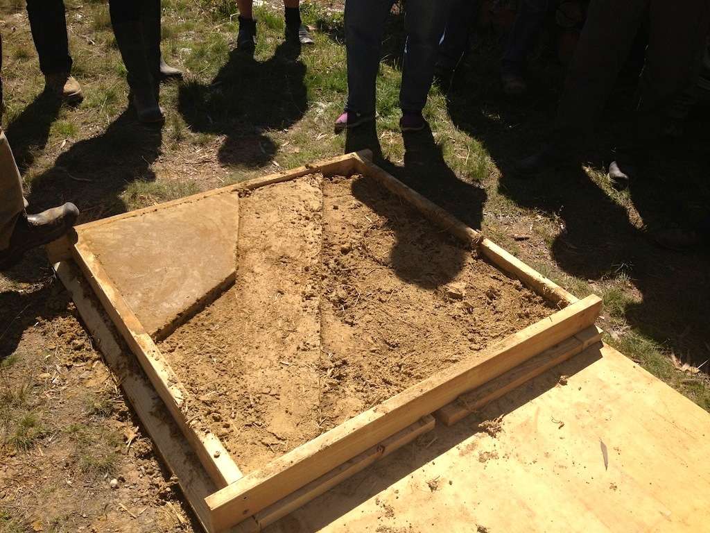 Sam Vivers taking students through a demo of earth floor building at Milkwood Farm