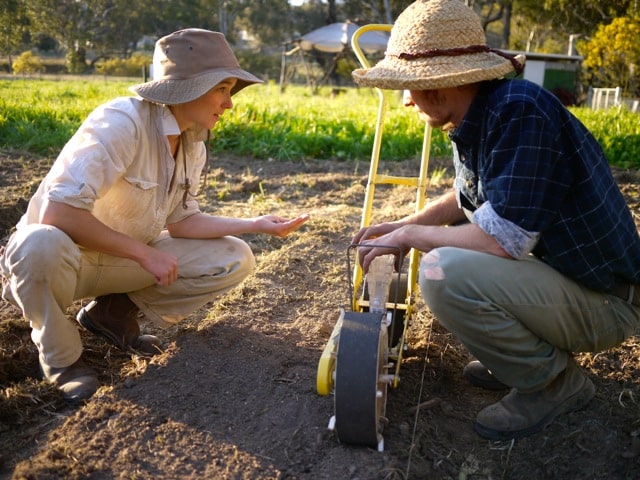 learning to use the seeder in the milkwood market garden