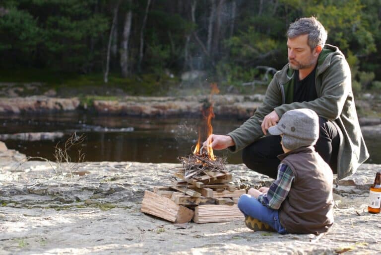Lighting a campfire on a rocky riverbank
