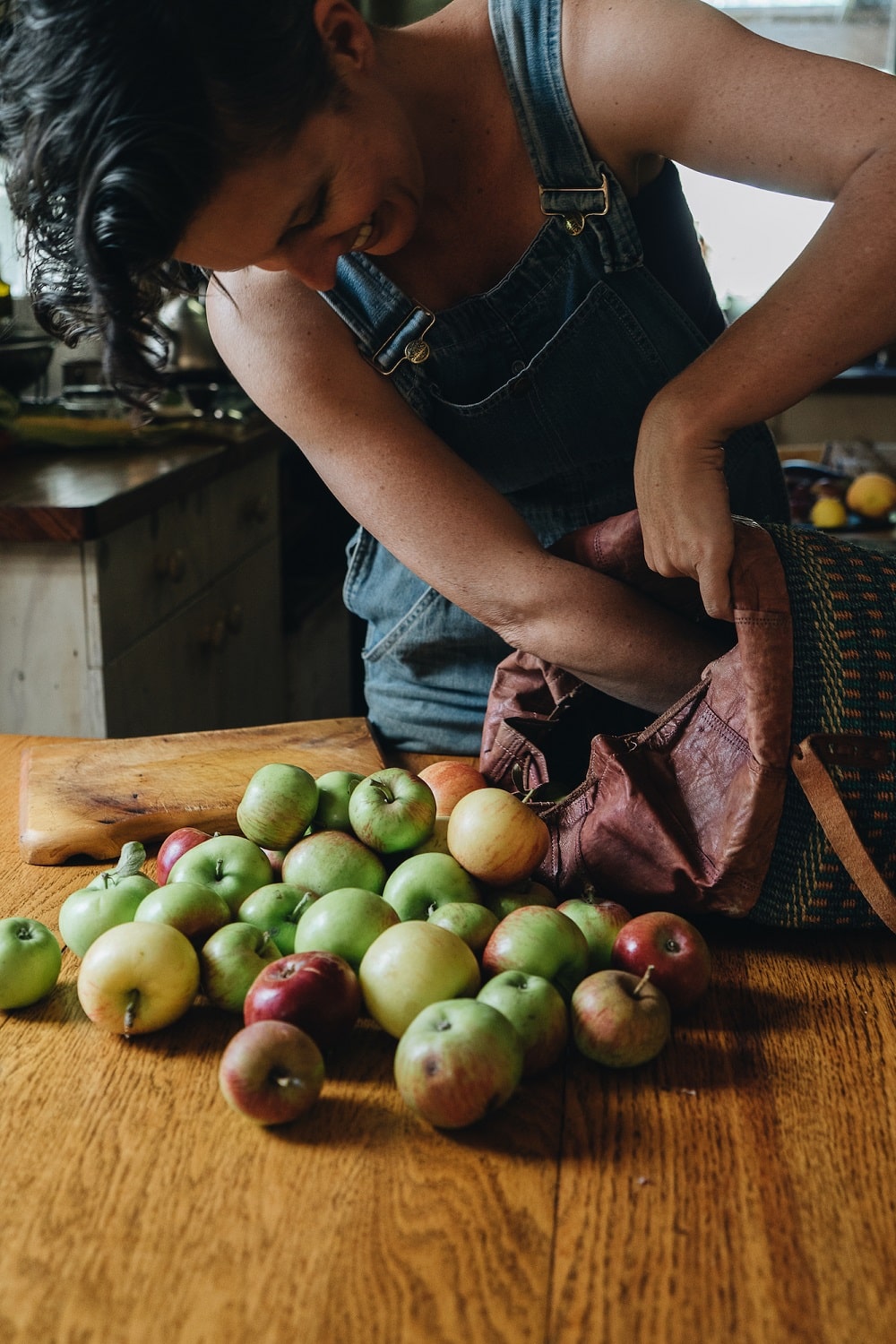 Kirsten unloading a bag of foraged apples and other fruit