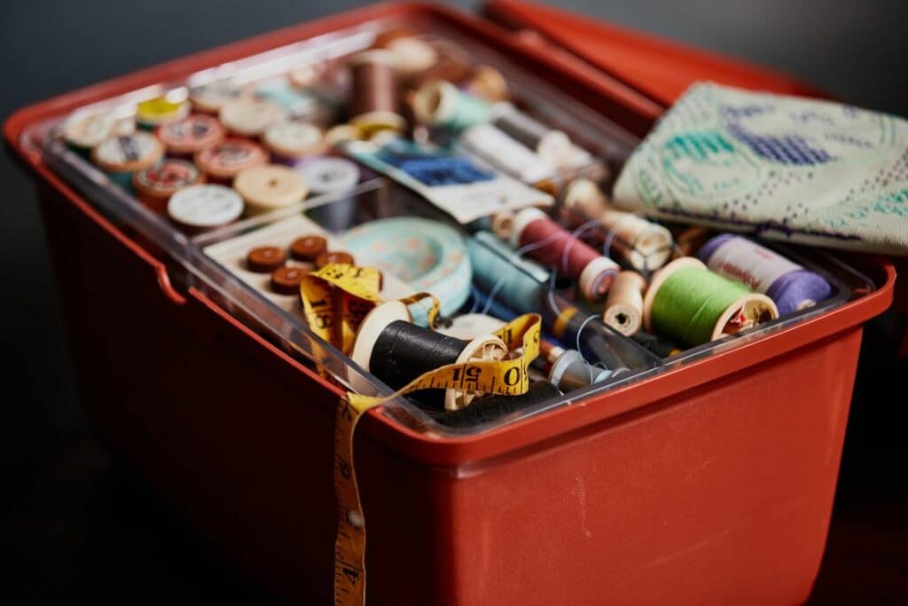 an old orange sewing box with tape measure and colourful thread