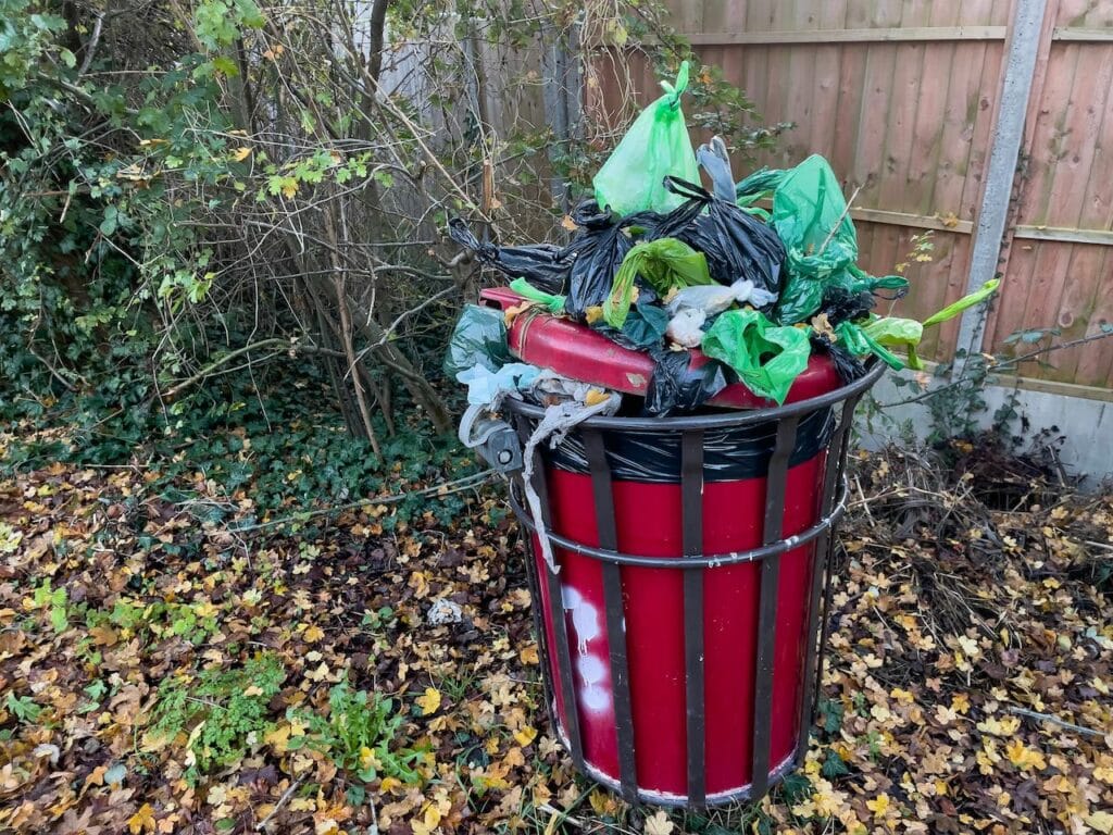 How to compost dog poop - a red bin full of plastic bags of pet poop