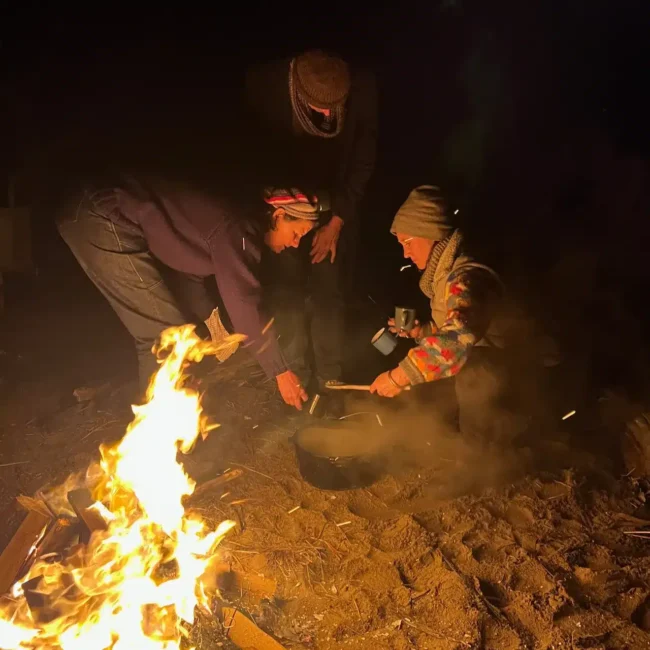 Taking the stew off the campfire to stir it