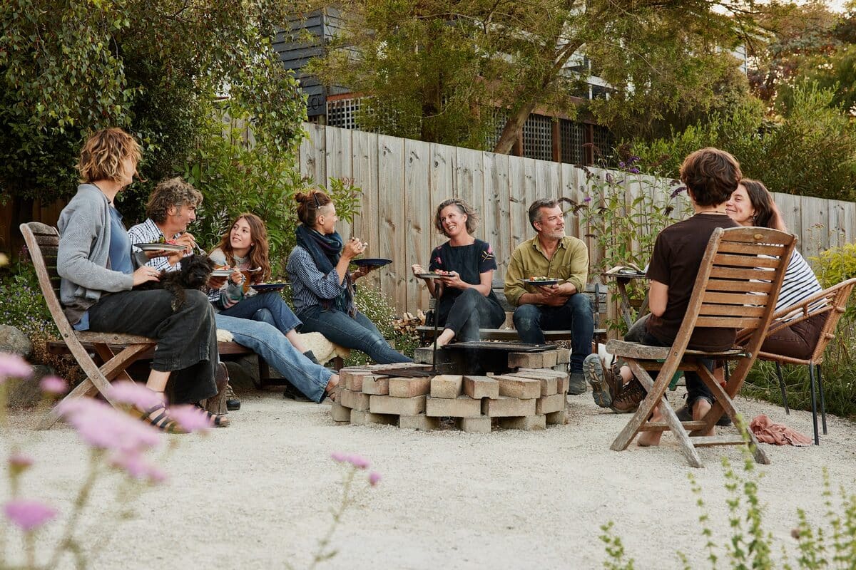 Kirsten and Nick of Milkwood sharing a meal around the fire pit with friends and neighbours in their backyard, southern Tasmania