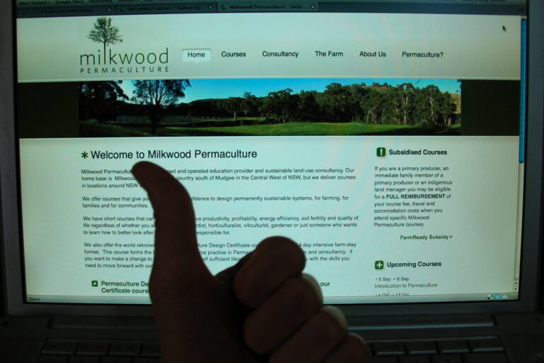 Thumbs up in front of a laptop showing the new Milkwood Permaculture website