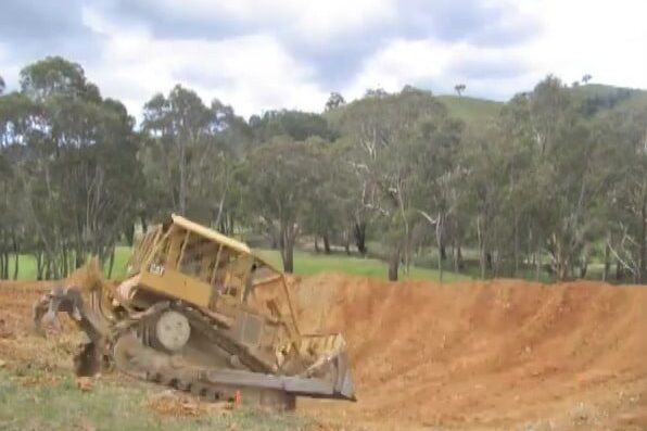 A bulldozer digging Milkwood's first dam in a cleared paddock