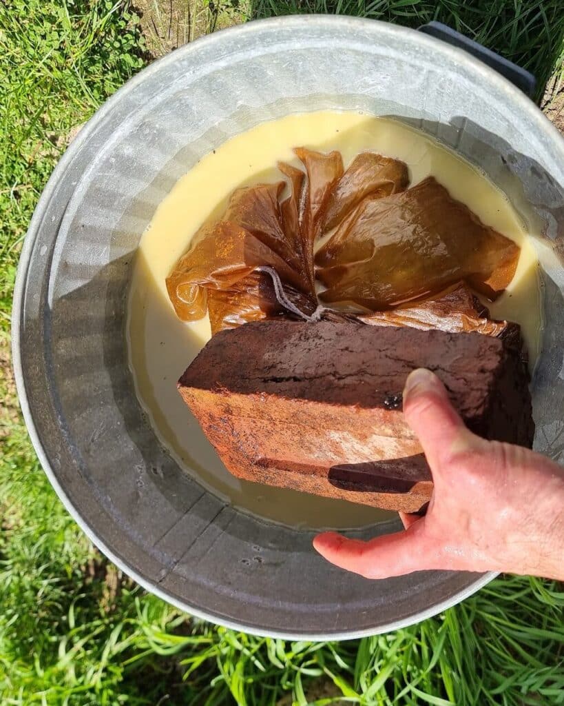 A brick weighing the bag down under the yellow lime water